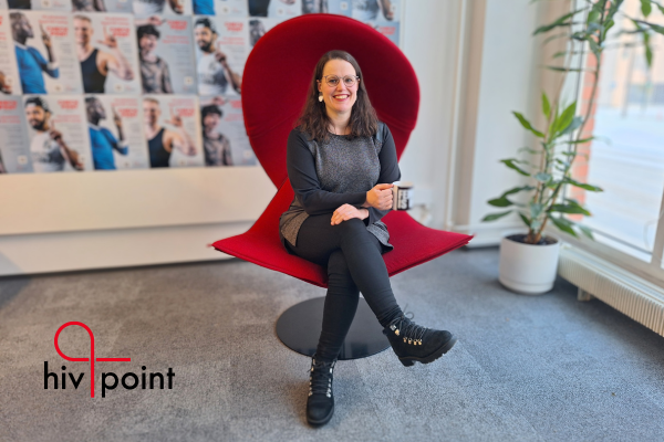 Hivpointin uusi toiminnanjohtaja Vilma Pietilä hymyilee ja istuu punaisella tuolilla Hivpointin toimistolla Kalasatamassa.