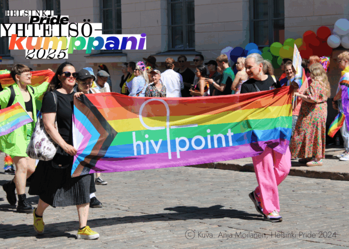 Anja Moilasen ottama valokuva Helsinki Pride 2024 -kulkueesta, jossa näkyy kaksi Hivpointin työntekijää kantamassa ylpeästi isoa sateenkaarilippua, jossa on Hivpointin logo.